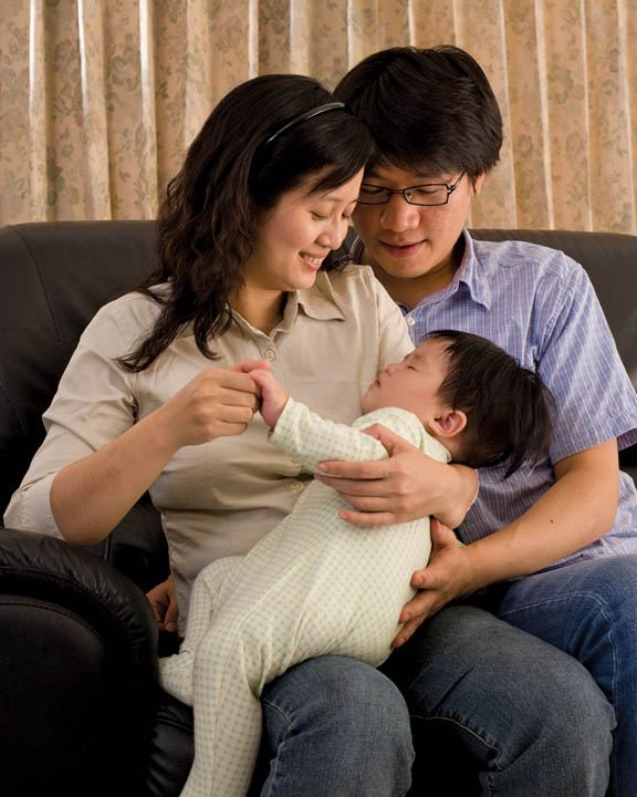 A young Mormon couple playing with their young child.