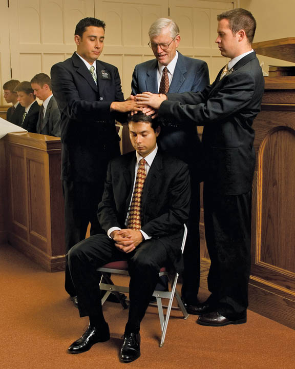 A photo of three men giving the Gift Holy Ghost to a man.