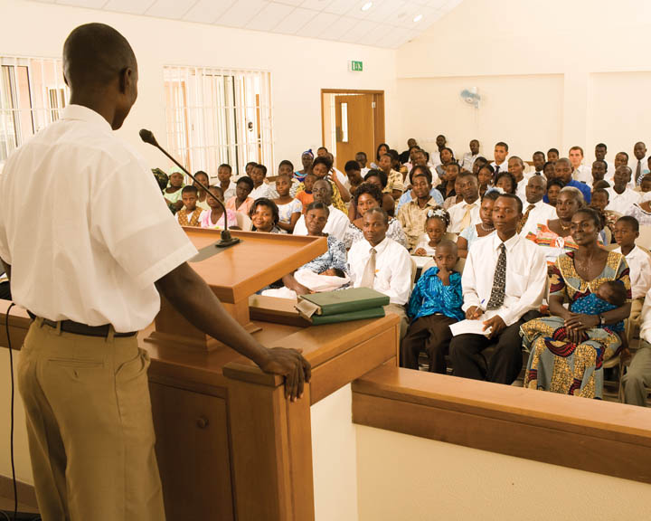 A photo of an African-American man giving a talk to a predominately African-American congregation at a Mormon church service.