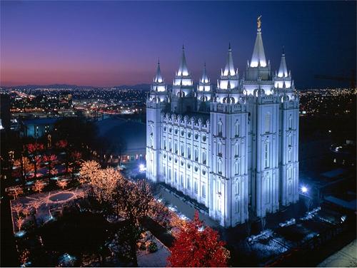 A photo of the Mormon Salt Lake City Temple at night with lights on the trees.