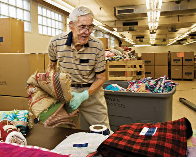 A photo of an elderly man helping to put together care packages.