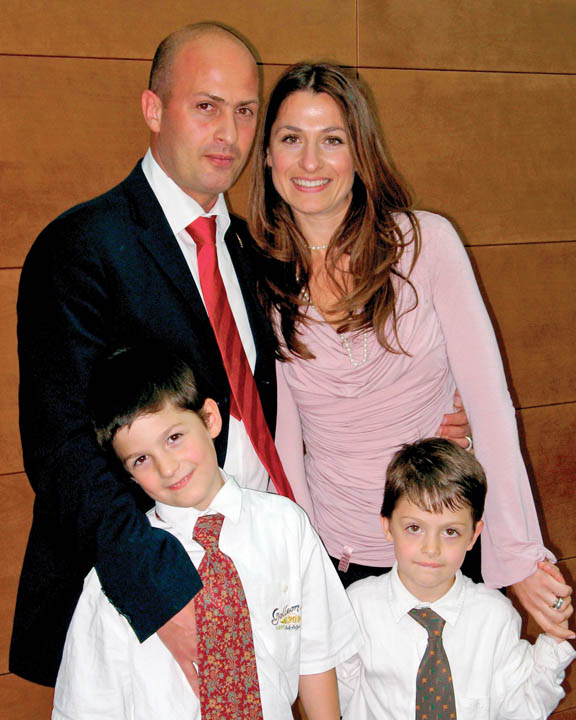 A photo of a Mormon Family dressed in their Sunday clothes. A father, mother, and two young boys.