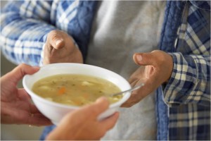 Serving others by volunteering in a soup kitchen