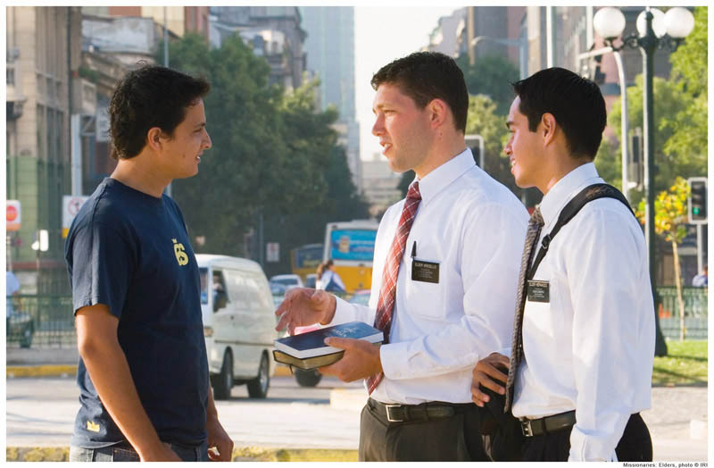 Mormon missionaries talk to a young man.