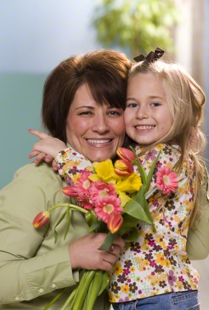 Child bringing flowers to mother.