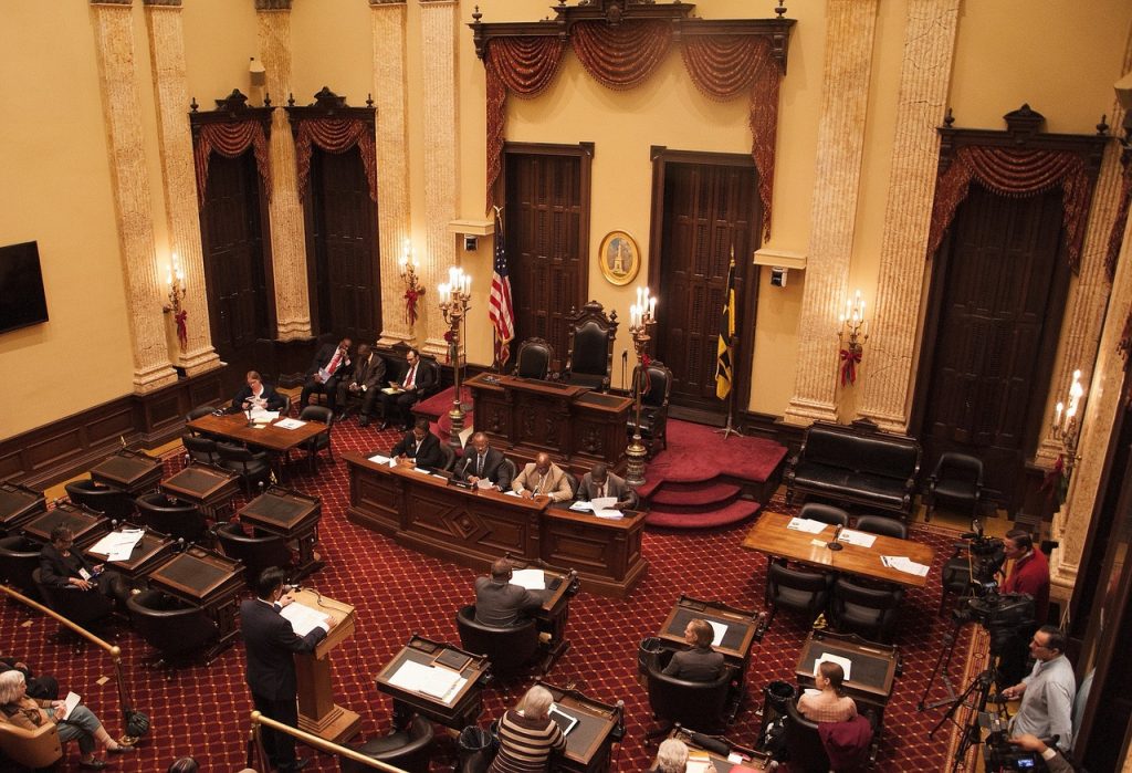 Council members meet at Baltimore City Hall. American government is about people working together for the good of the community.