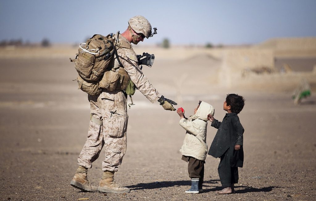 An American soldier interacts with young children.