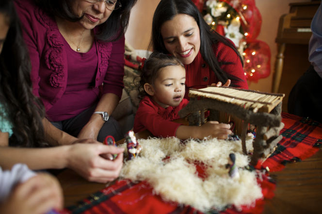 A family sets up a Nativity set to celebrate Christmas.