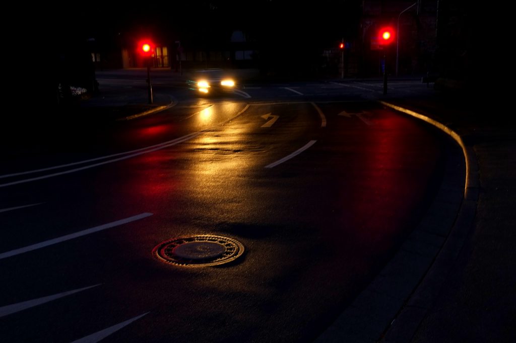 A car stops at a red light at night. Stoplights can be a blessing or a burden, just like God's commandments.