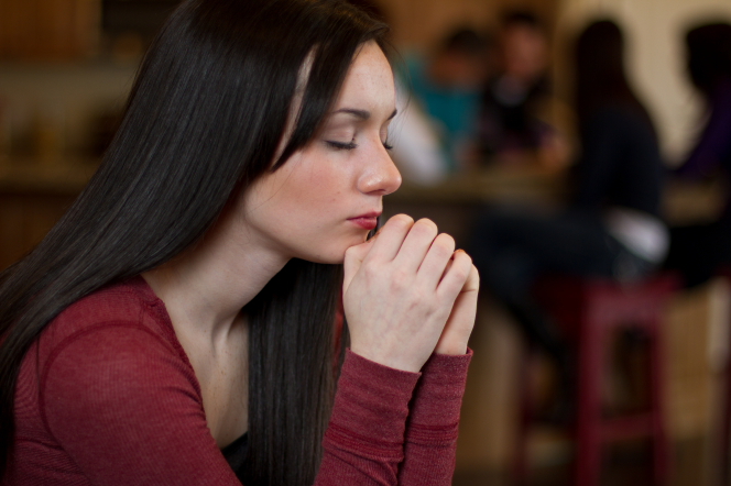 A teenager prays. We can turn to God in prayer to help us forgive others.